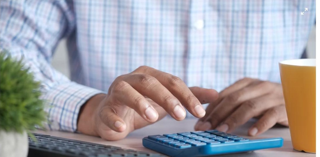 Small business owner using a calculator - UAE Small Business Relief 2029