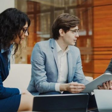 Professionals reviewing data on a tablet - UAE Competition Framework 2026